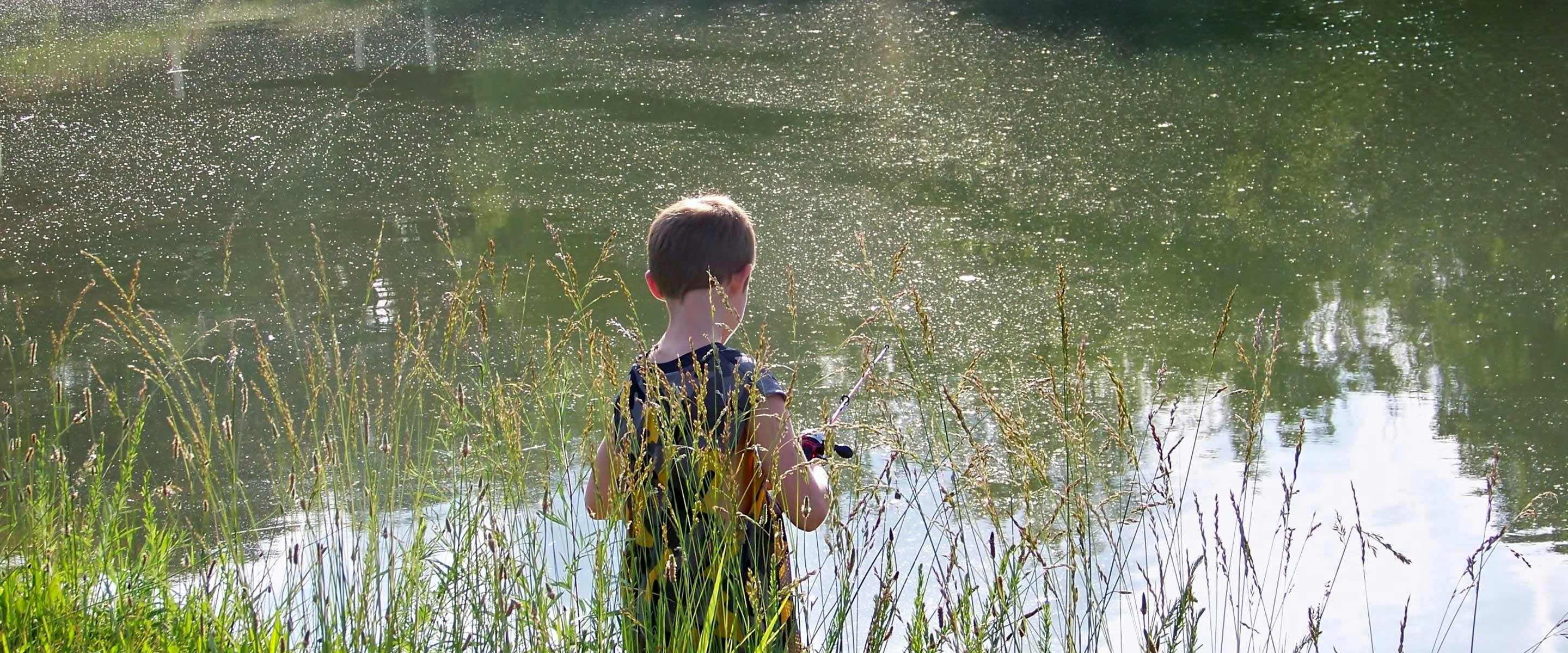 boy fishing with pole from shore
