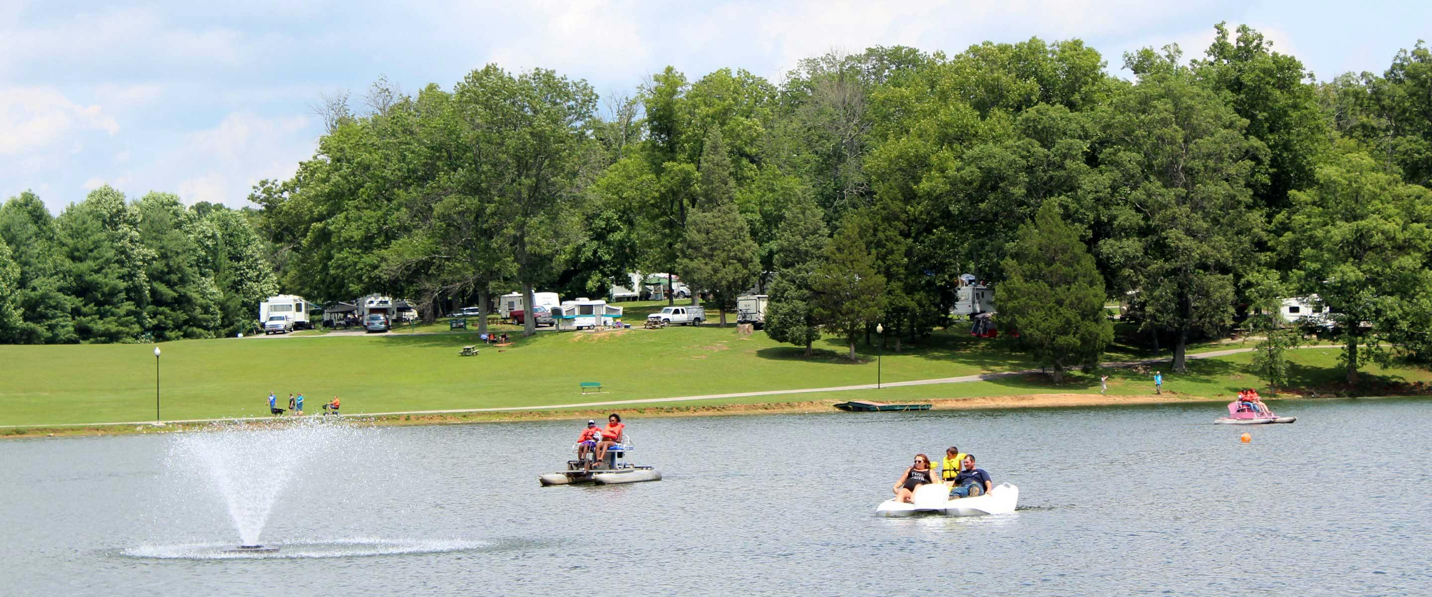 three paddleboats boating around the lake fountain