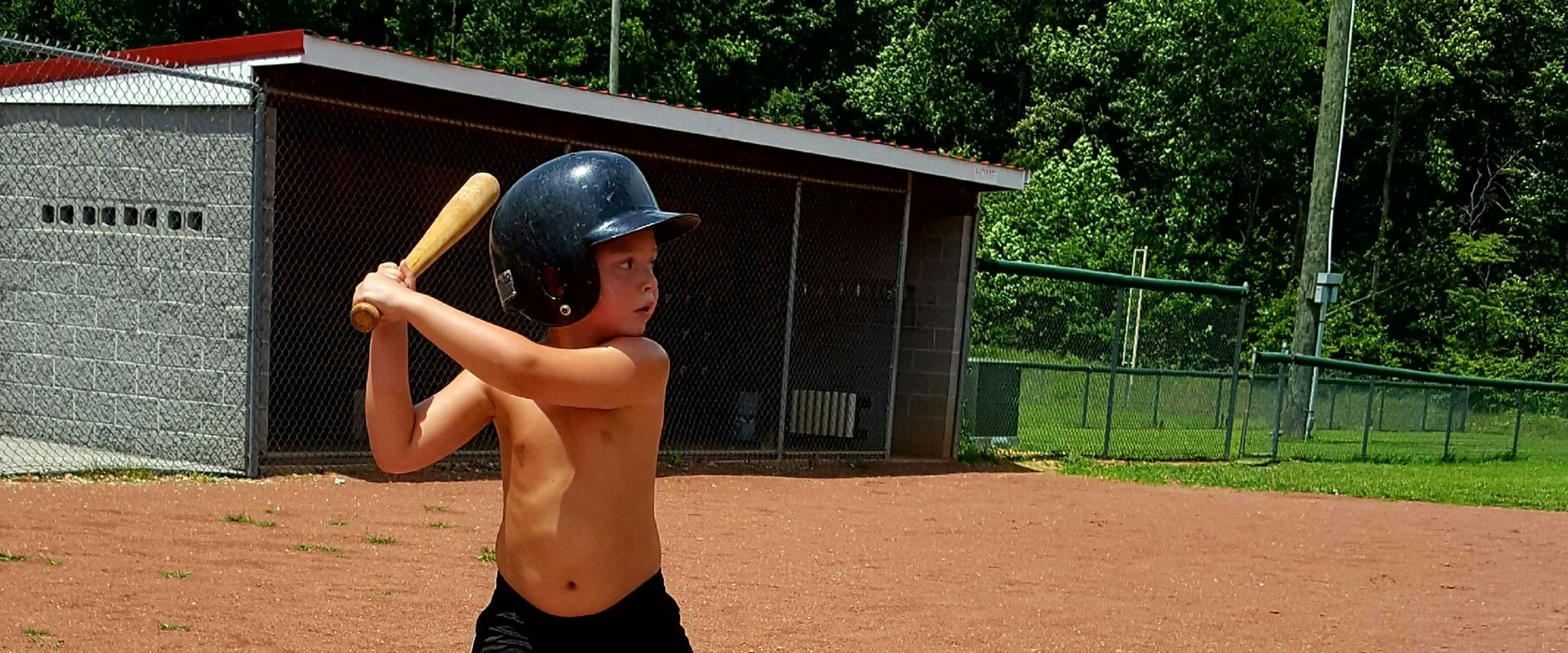 boy up to bat on home plate at ball field